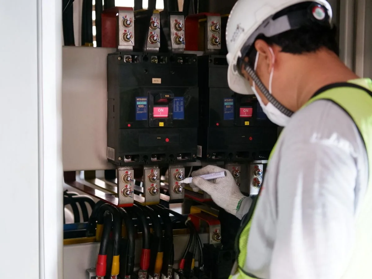 Técnico con casco inspeccionando tablero de media tensión